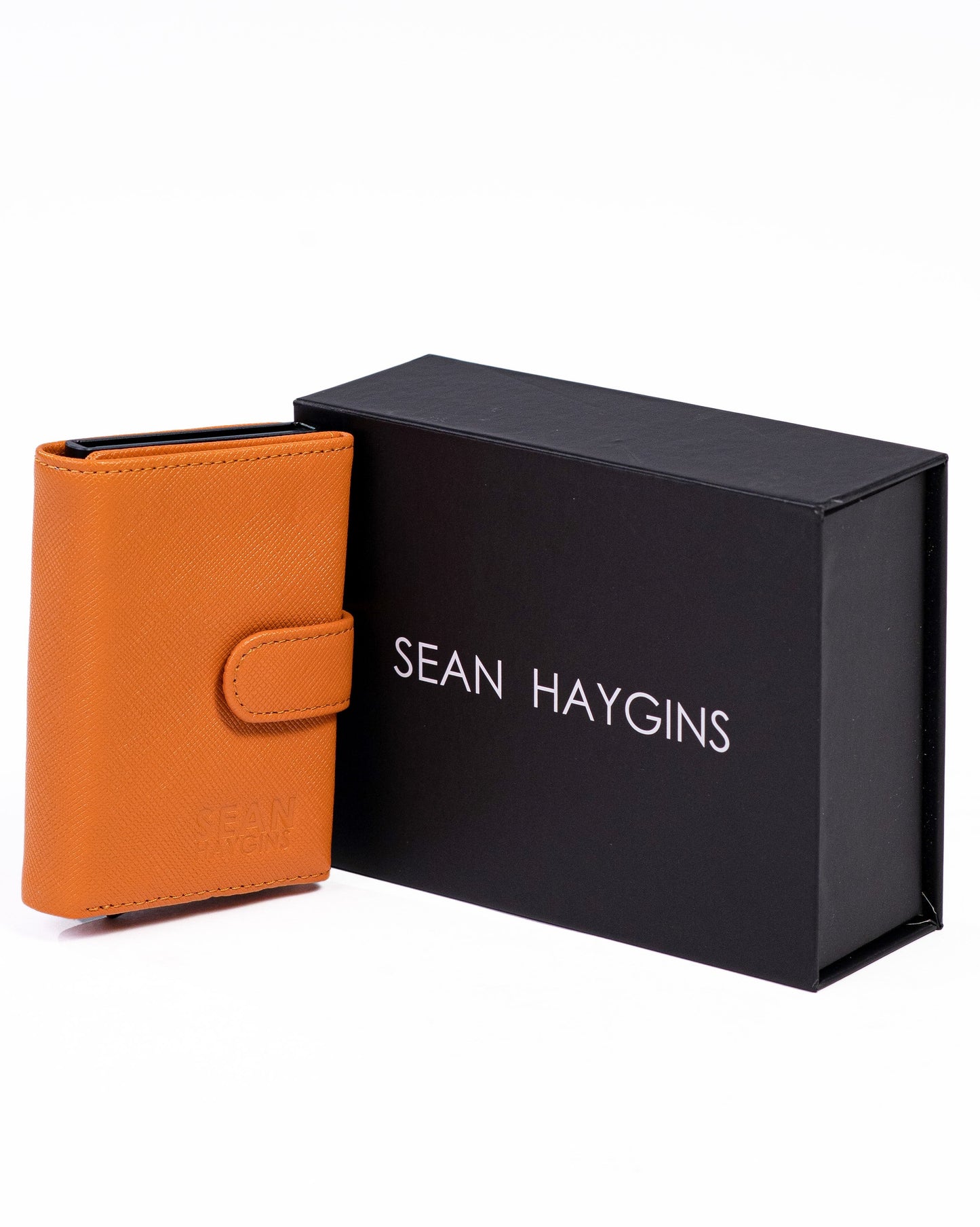 Orange wallet next to a black box with 'Sean Haygins' branding on a white background