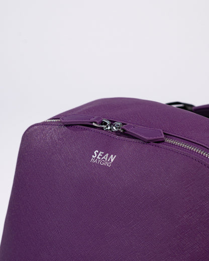 Purple backpack with 'Sean Haygins' branding on a light gray background