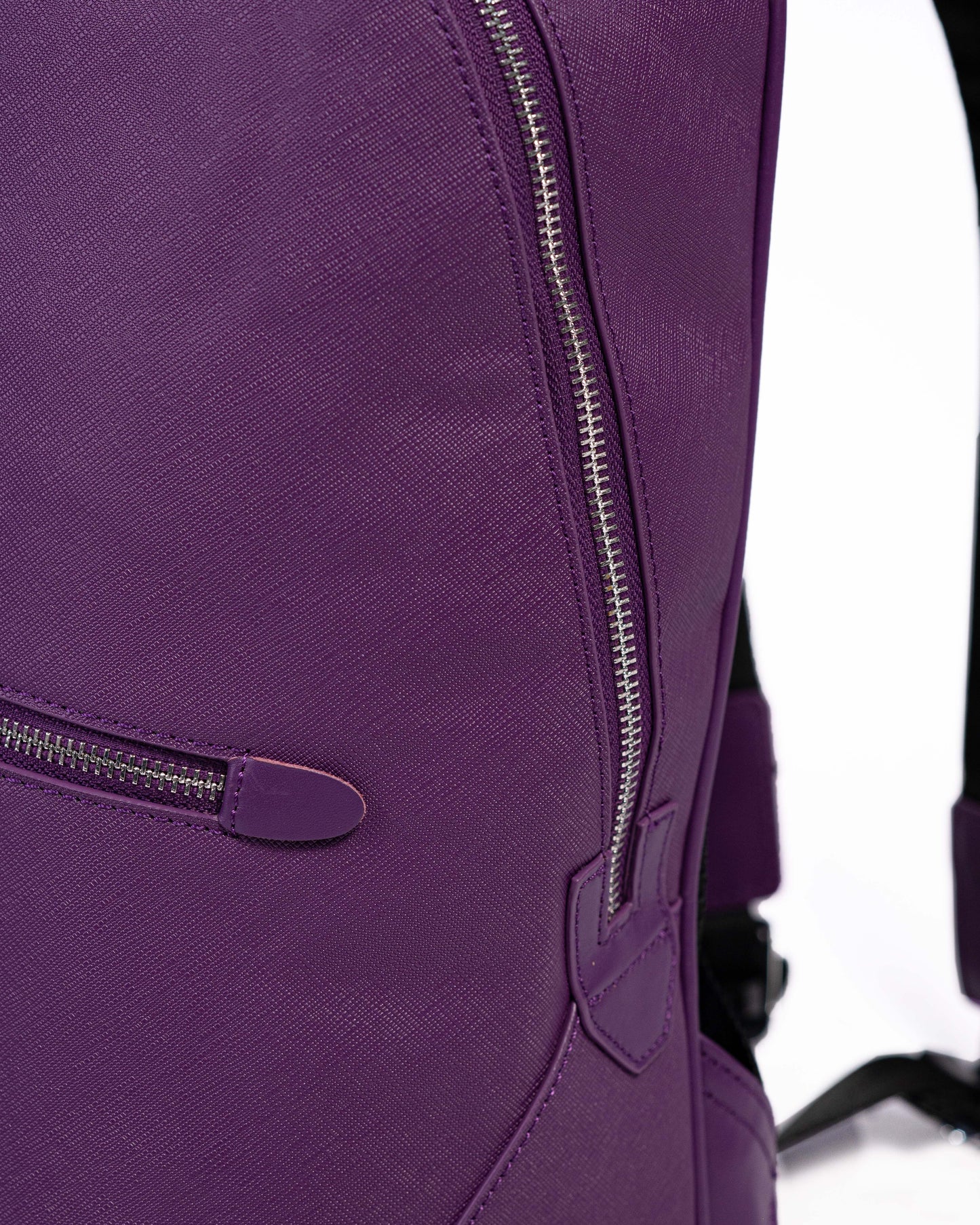 Close-up of a purple backpack with zippers on a white background