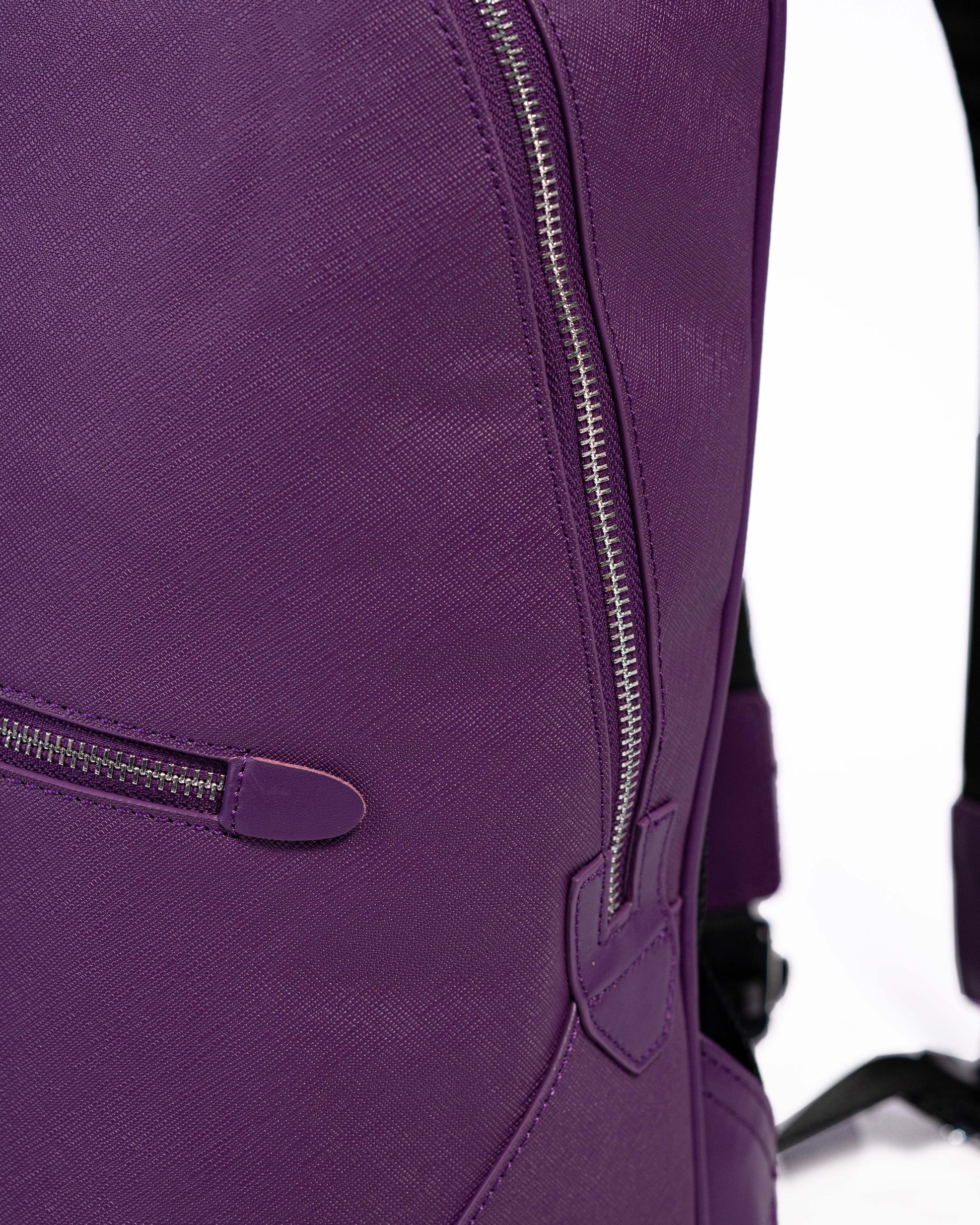 Close-up of a purple backpack with zippers on a white background