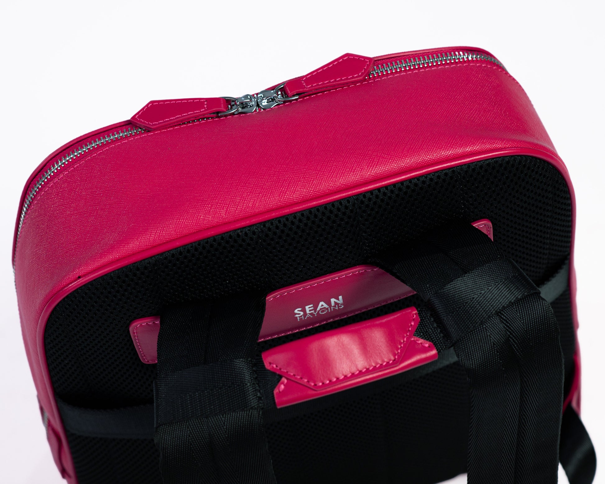 Pink backpack with a visible brand name on a white background