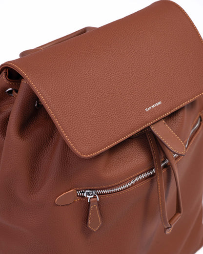 Brown leather backpack with a visible brand name on a white background