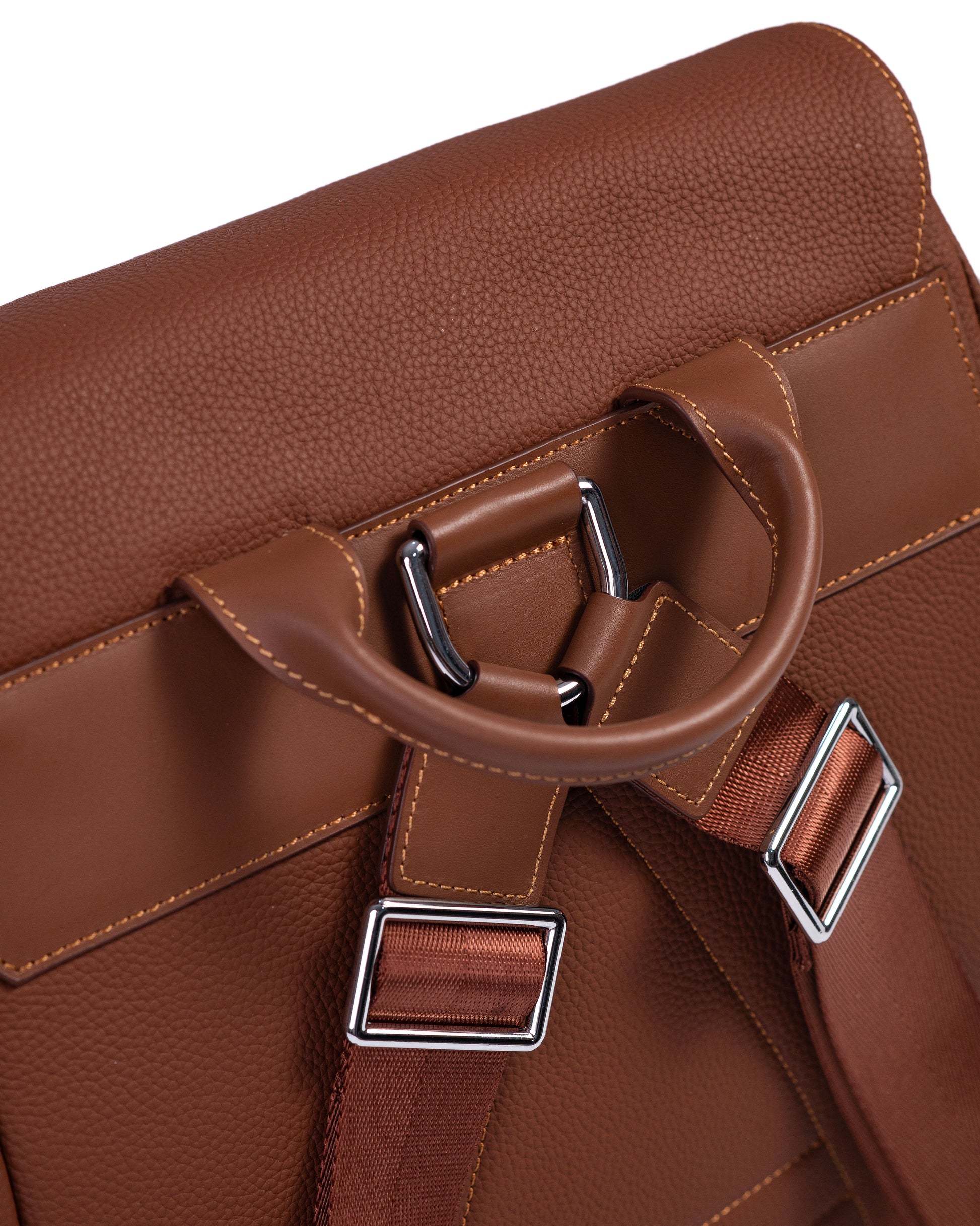Close-up of a brown leather bag with metal buckles on a white background