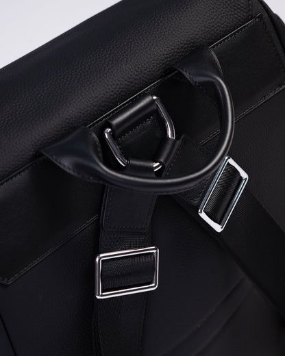 Close-up of a black leather bag with silver hardware on a white background